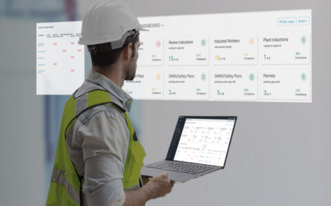 Image of someone holding a laptop looking at HSE construction dashboards
