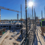 Two construction workers in high vis, wearing hard hats on site representing safe practices for Safe Work Month